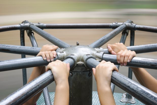 the hands of children on playground apparatus